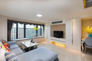 un soggiorno con un divano e una TV di Keluowei International Serviced Apartment Guangzhou Sun-yet.memorial Branch a Canton