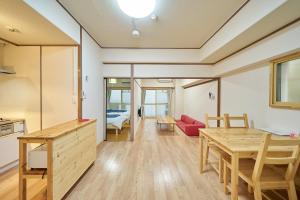 a kitchen and living room with a red couch and a table at Canello Hotel in Sendai