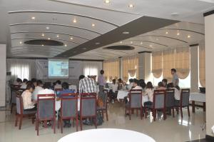 een groep mensen die aan een tafel in een kamer zitten bij Monte Carlo Hotel Hai Phong in Hai Phong