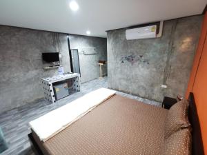 1 dormitorio con 1 cama y TV. en Viman Resort en Chon Buri