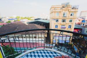 - un balcon avec vue sur une ville avec des bâtiments dans l'établissement The Opera Hotel Hải Phòng, à Hai Phong