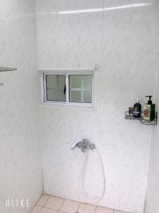y baño blanco con ducha y ventana. en Star Valley en Nanzhuang