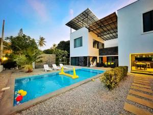 a house with a swimming pool in front of a house at Relax Pool Villa Pranburi in Pran Buri