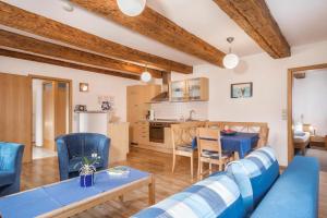 a living room with a blue couch and a table at Ferienwohnung Nr 3 in Deggenhausertal