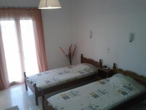 una camera da letto con due letti e una finestra di Villa Stefania ad Acharavi