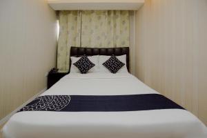 a bedroom with a white bed with two pillows at Newgrange Condotel in Manila