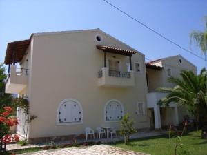 una casa bianca con porte bianche e balcone di Villa Stefania ad Acharavi