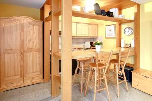 a kitchen with wooden cabinets and a table and chairs at Comfortable apartment with sea view in Westerland-Sylt, 35 m² in Westerland (Sylt)