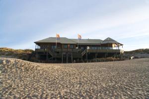 a large wooden house on the beach with sand at Comfortable apartment with sea view in Westerland-Sylt, 35 m² in Westerland (Sylt)