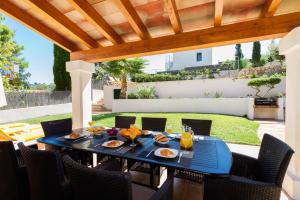 una mesa con comida en el patio en 4 bedrooms villa at Pollensa 100 m away from the beach with sea view private pool and enclosed garden, en Pollensa