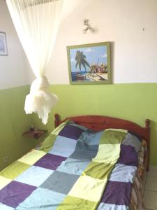 a bedroom with a bed with a colorful quilt at Maison de 2 chambres avec jardin clos et wifi a Le Moule a 2 km de la plage in Le Moule