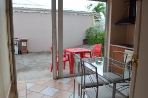 a glass door leading to a patio with a table and chairs at Appartement d'une chambre avec jardin clos et wifi a Le Diamant a 1 km de la plage in Le Diamant