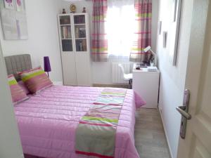 a bedroom with a pink bed and a desk at Maison charmante à La Londe-les-Maures, jardin clôturé in La Londe-les-Maures