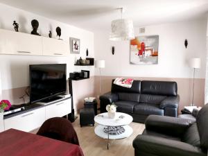 a living room with a couch and a tv at Maison charmante à La Londe-les-Maures, jardin clôturé in La Londe-les-Maures