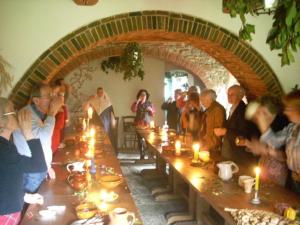 a group of people sitting at a long table with candles at All'Antico Silbule in Capolona