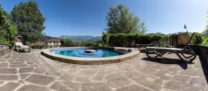 a patio with a pool with a table and a bench at Comfortable house with pool in Castelnuovo di Garfagnana in Castelnuovo di Garfagnana