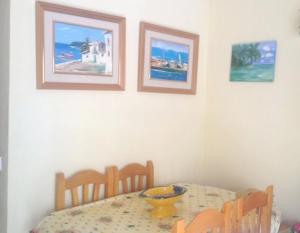 a dining room with a table and three pictures on the wall at 2 bedrooms appartement at San Javier 100 m away from the beach with sea view shared pool and furnished balcony in La Manga del Mar Menor