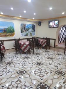 comedor con mesas, sillas y pinturas en las paredes en GAH en Tsaghkadzor