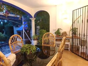 patio ze szklanym stołem i wiklinowymi krzesłami w obiekcie 4 bedrooms villa with sea view private pool and enclosed garden at Estepona 1 km away from the beach w mieście Estepona