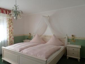 - une chambre avec un lit blanc à baldaquin dans l'établissement Alte Weinstuben Steinfelder Hof Garni, à Ellenz-Poltersdorf