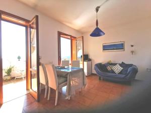 a dining room with a table and a couch at 2 bedrooms house at Letojanni 500 m away from the beach with sea view furnished terrace and wifi in Letojanni