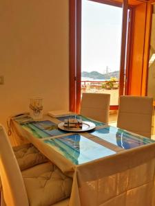 a dining room with a glass table and chairs at 2 bedrooms house at Letojanni 500 m away from the beach with sea view furnished terrace and wifi in Letojanni