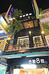 un edificio con un balcón con plantas. en Ho Huan B & B, en Kenting