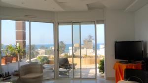 a living room with a large sliding glass door at 4 bedrooms appartement at Mahdia 100 m away from the beach with sea view furnished terrace and wifi in Mahdia