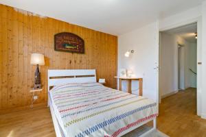 a bedroom with a bed and a wooden wall at Chalet spacieux à Wangenbourg-Engenthal avec vue panoramique in Wangenbourg