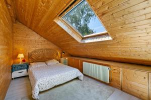 a bedroom with a bed in a wooden room with a window at Chalet spacieux à Wangenbourg-Engenthal avec vue panoramique in Wangenbourg