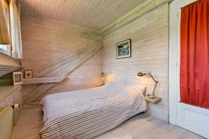 a small bed in a room with wooden walls at Chalet spacieux à Wangenbourg-Engenthal avec vue panoramique in Wangenbourg +18 photos
