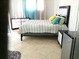 a bedroom with a bed with colorful pillows on it at Elegant Villa with Sea View in Sosúa | Private Pool in Sosúa +13 photos