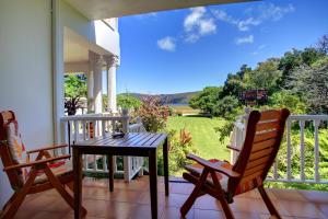 a balcony with a table and chairs and a view of a yard at Waterfront Lodge in Knysna