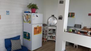 a kitchen with a white refrigerator in a room at Bungalow d'une chambre avec vue sur la mer piscine partagee et jardin clos a Saint Leu a 7 km de la plage in Saint-Leu