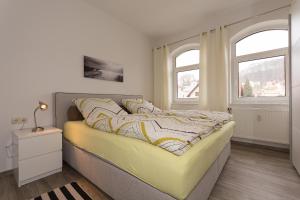 a bedroom with a large bed and two windows at Traumferienwohnung in Sellin / Rügen in Ostseebad Sellin