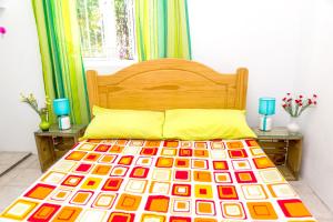 a bed with a colorful comforter in a bedroom at 3 bedrooms apartement at Pamplemousses 800 m away from the beach with private pool enclosed garden and wifi in Pamplemousses Village