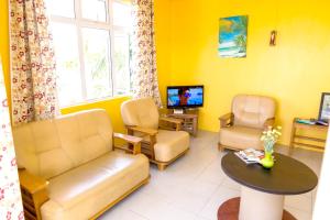 a waiting room with a couch and a table and a tv at 3 bedrooms apartement at Pamplemousses 800 m away from the beach with private pool enclosed garden and wifi in Pamplemousses Village
