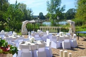 a set of white tables and chairs in a garden at Villa spacieuse et conviviale à Courtenay avec jardin clôturé in Courtenay