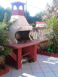 un horno al aire libre sentado en una mesa en un jardín en Charming House in Santa Maria del Focallo with Enclosed Garden, en Santa Maria del Focallo
