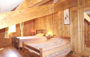two beds in a room with wooden walls at Villa Luxueuse Grillon - Piscine in Grillon
