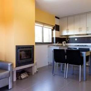 cocina con mesa y sillas y TV en 2 bedrooms bungalow with city view shared pool and jacuzzi at Pinhel, en Pinhel