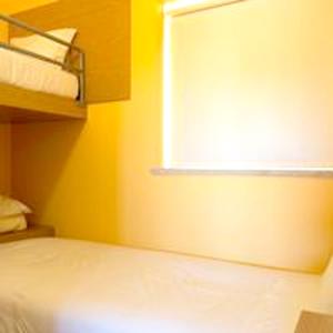 Habitación amarilla con cama y ventana en 2 bedrooms bungalow with city view shared pool and jacuzzi at Pinhel, en Pinhel