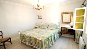 a bedroom with a bed and a mirror and a chair at Maison charmante à Lannes avec terrasse et jardin, animaux acceptés in Lannes