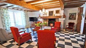 a living room with red chairs and a fireplace at Maison charmante à Lannes avec terrasse et jardin, animaux acceptés in Lannes