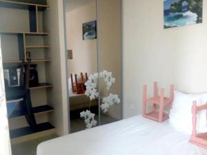 a bedroom with a bed with a mirror and a chair at Studio avec jardin clos et wifi a Hirel in Hirel