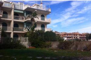 a large apartment building with people on the balcony at One bedroom appartement at Mascali 10 m away from the beach with sea view furnished terrace and wifi in Mascali