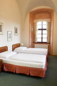 two beds in a room with a window at Adalbert Ecohotel in Prague