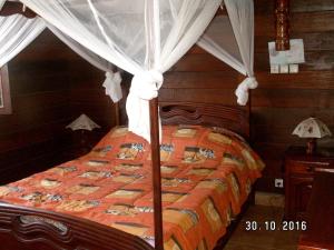 a bedroom with a bed with a canopy at 4 bedrooms house at Toamasina 50 m away from the beach with sea view and enclosed garden in Toamasina