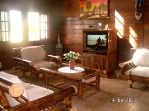 a living room with two chairs and a tv at 4 bedrooms house at Toamasina 50 m away from the beach with sea view and enclosed garden in Toamasina