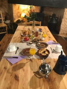 una mesa de madera con comida y vasos de zumo de naranja en Studio with balcony and wifi at Robledillo de Gata, en Robledillo de Gata